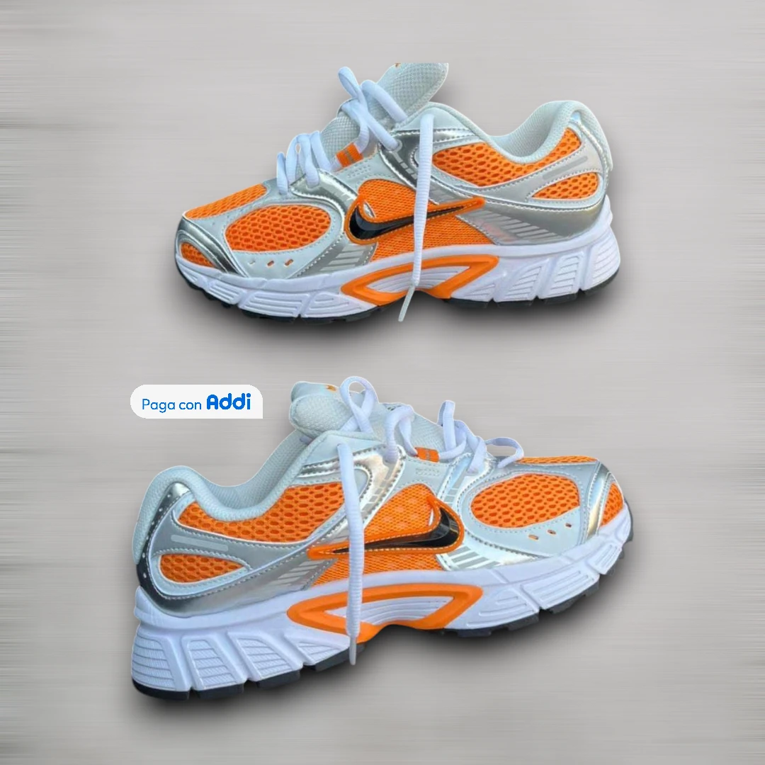 Tenis Nike Vomero blanco naranja plateado estilo running para caminar con amortiguación premium y diseño deportivo moderno